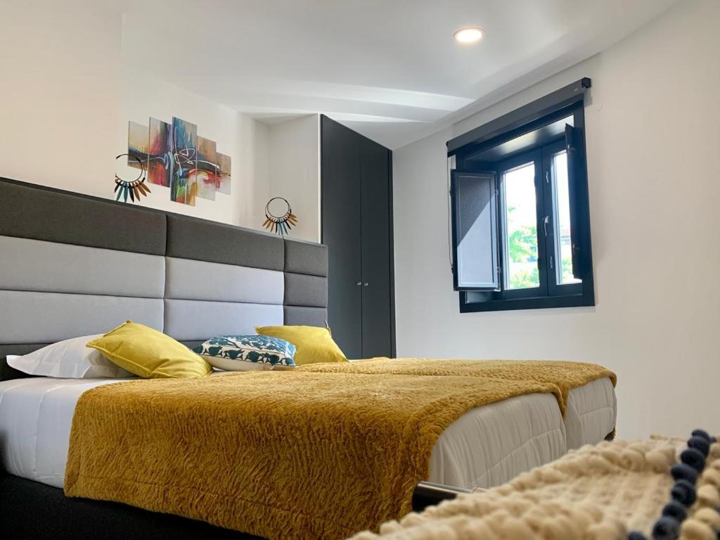 a bedroom with a large bed and a window at Taska Vila Velha in Mirandela