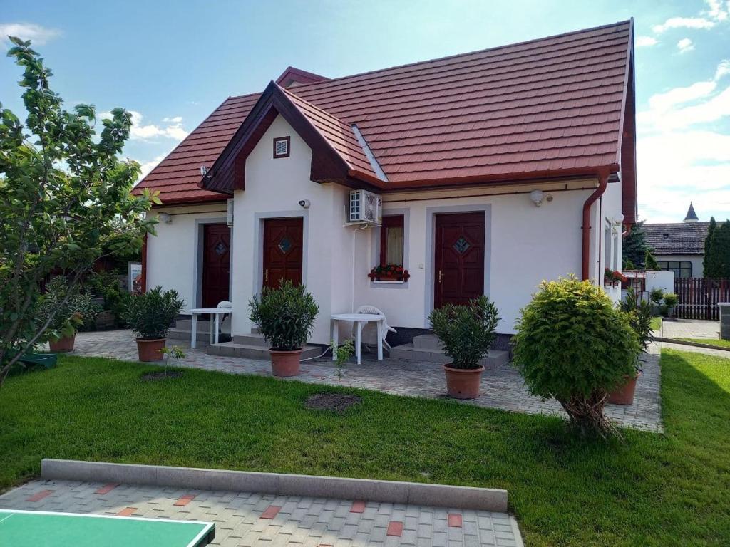 een klein wit huis met een rood dak bij Kertész Vendégház in Hegykő