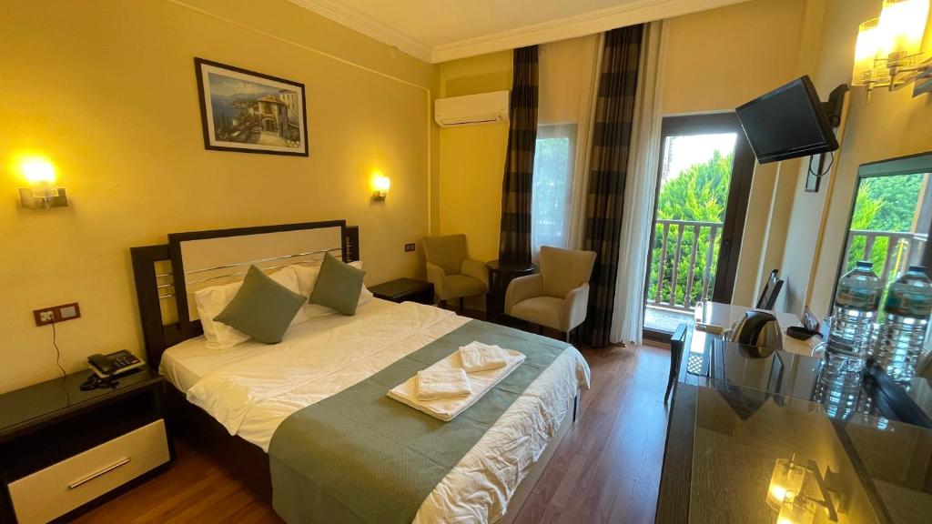 オルデニズにあるHotel Oludenizのベッドとテレビが備わるホテルルームです。