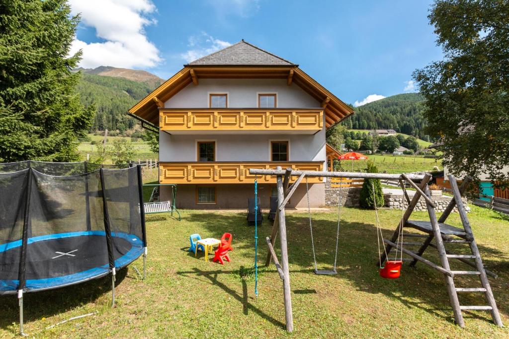 a yard with a swing set and a house at Ferienhaus Christine Bauer in Hintergöriach