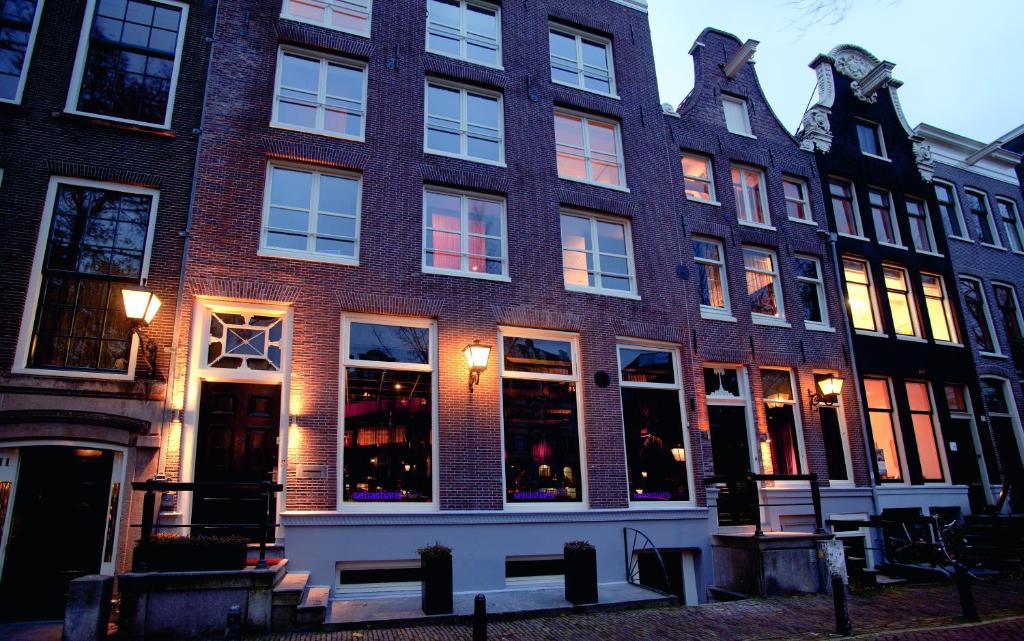 a brick building with many windows on a street at Hotel Sebastians in Amsterdam
