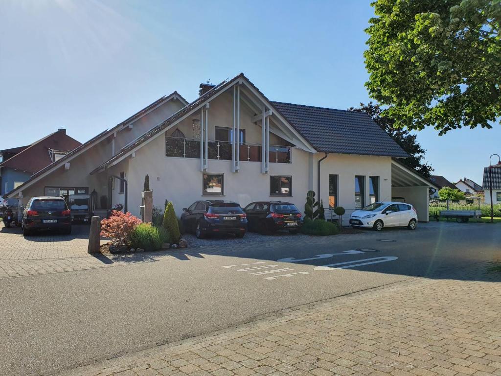 een huis met auto's geparkeerd op een parkeerplaats bij Gästehaus Sonja in Rust