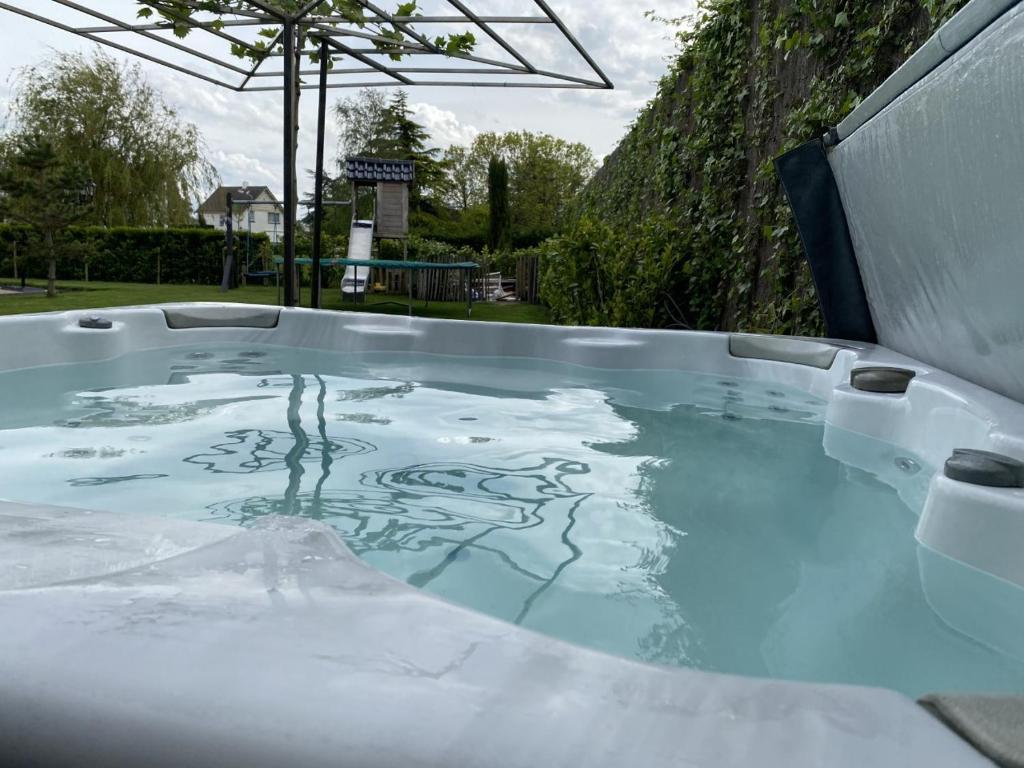 a hot tub filled with water in a backyard at Slapen bij van O in Yerseke