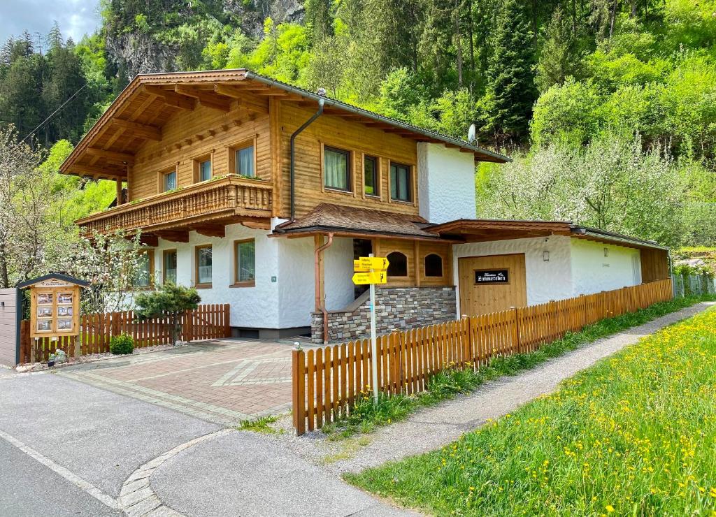 a house with a wooden fence in front of it at Ferienhaus Zimmereben in Mayrhofen