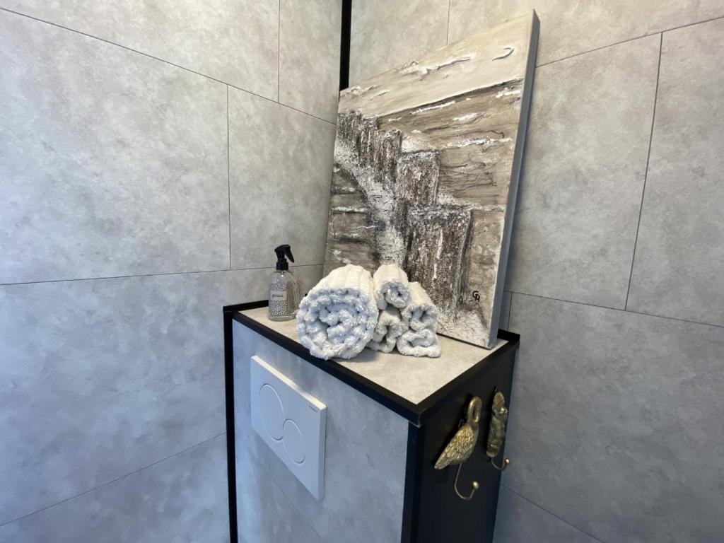 a bathroom with a counter with a painting on the wall at Slapen bij van O in Yerseke