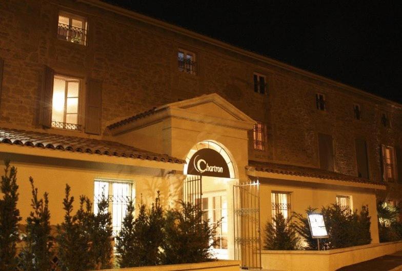 un bâtiment avec un panneau à l'avant dans l'établissement Hotel Restaurant Chartron, à Saint-Donat-sur-lʼHerbasse
