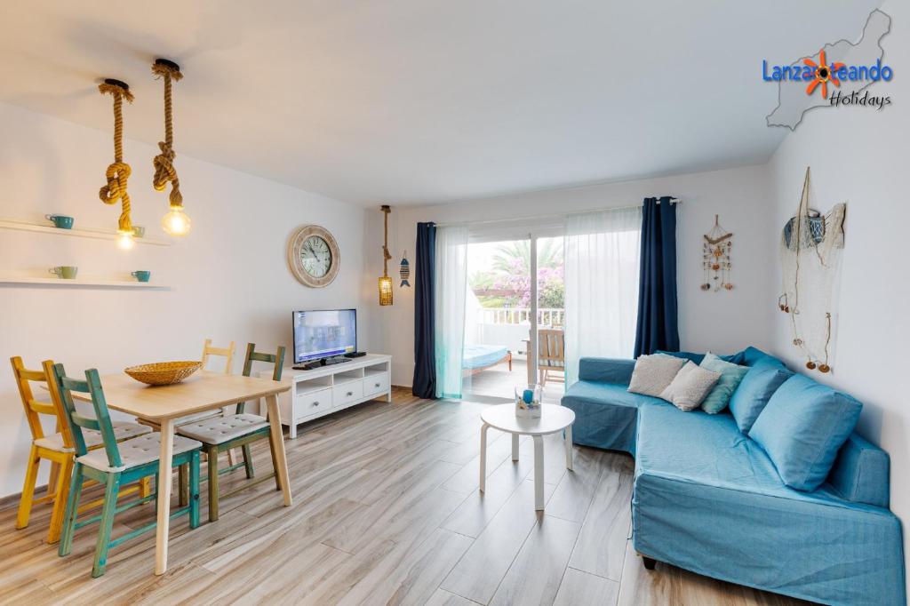 salon z niebieską kanapą i stołem w obiekcie Vivienda Vacacional Buganvillas w Costa Teguise