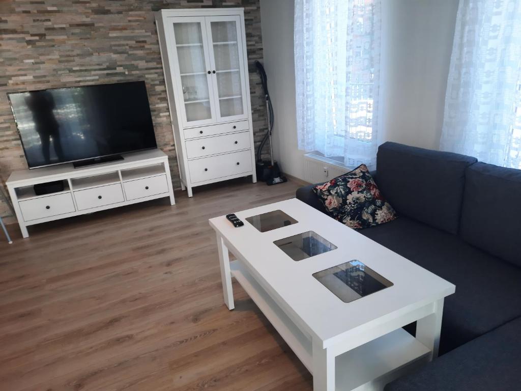 a living room with a couch and a tv at Apartament za świerkami in Kołobrzeg