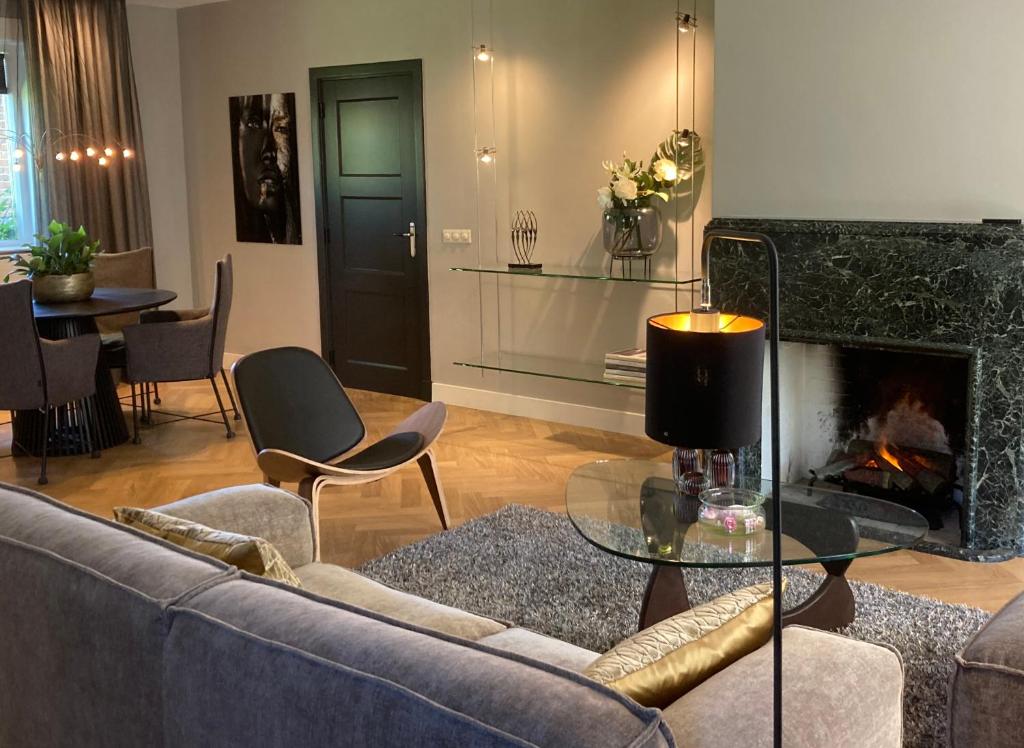 a living room with a couch and a fireplace at Hoeve Altena Apartment in Woudrichem