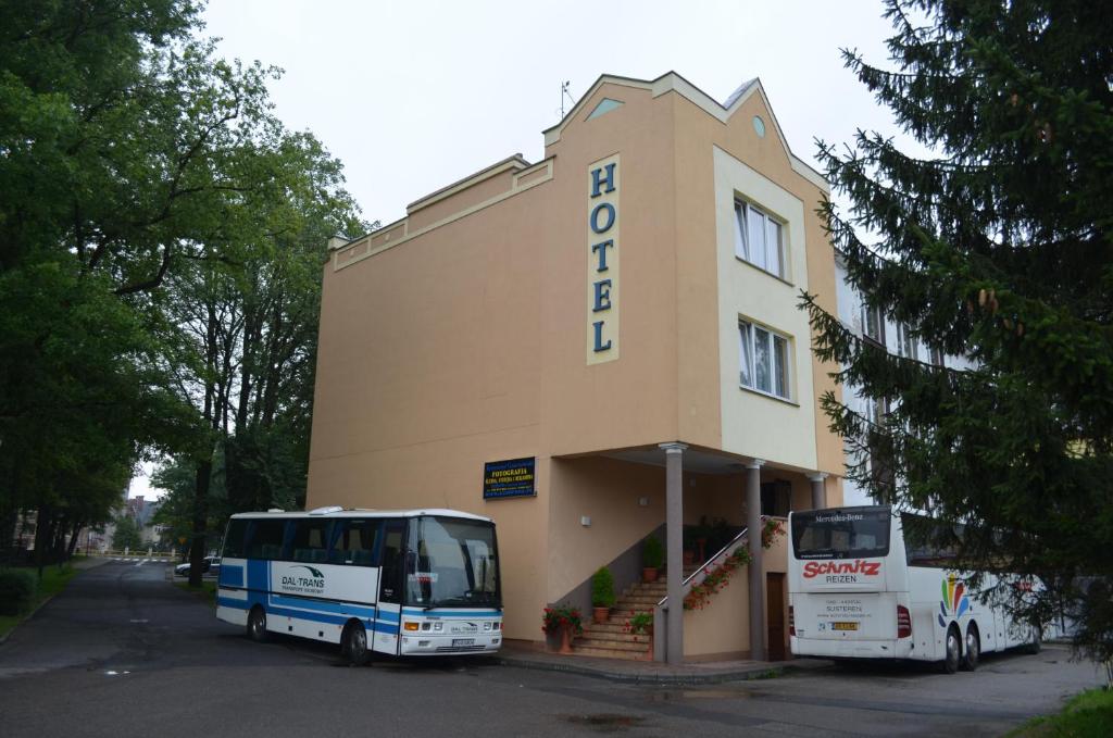 twee bussen geparkeerd voor een gebouw bij Hotel Olimp in Chojnice