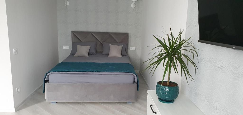 um quarto com uma cama e um vaso de plantas em Квартира в центре em Poltava