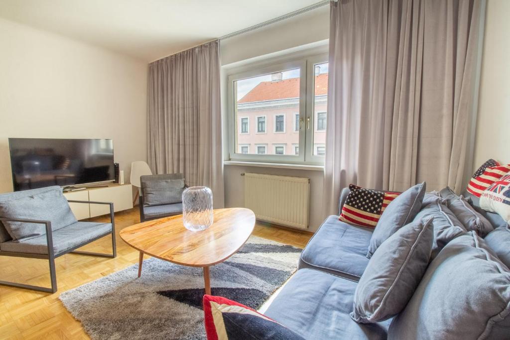 un soggiorno con divano blu e tavolo di Naschmarkt Premium Apartment in "Your Vienna" a Vienna
