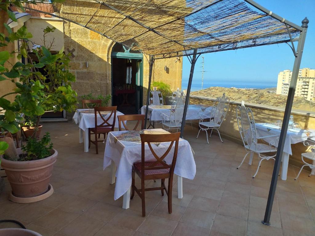 um restaurante com mesas e cadeiras e vista para o oceano em B&B Batarà - "La Terrazza del Centro" em Agrigento
