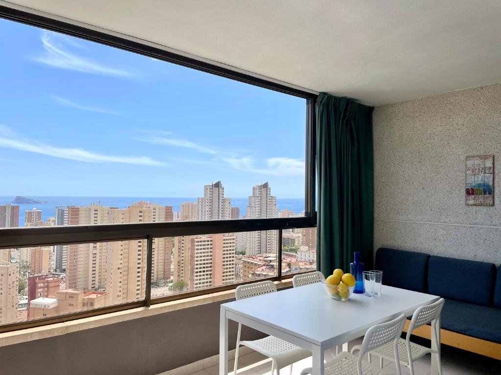 Zimmer mit einem weißen Tisch und einem großen Fenster in der Unterkunft Apartamentos Paraiso 10 by Gestaltur in Benidorm