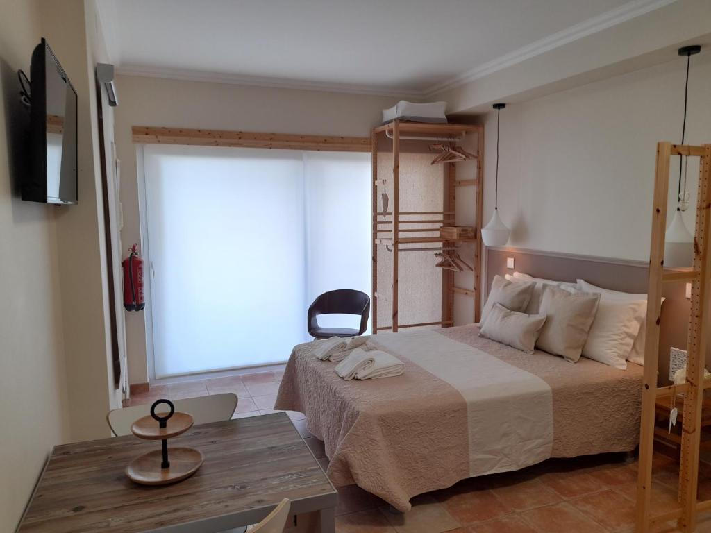 a bedroom with a bed and a table and a window at Cantinho do Burgau in Burgau