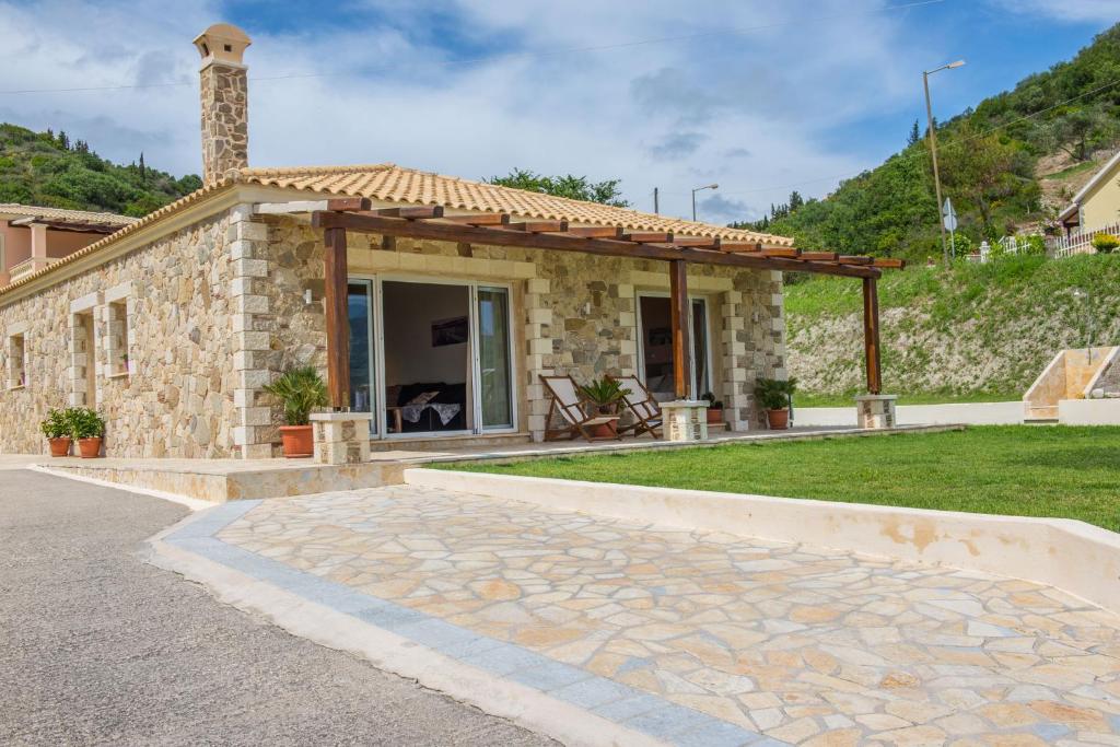 a stone house with a pavilion on the side of it at Villas Porto Kamini Afionas Corfu in Afionas