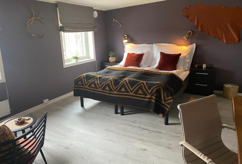 a bedroom with a bed with pillows and a chair at 8 Seasons Hotel in Varangerbotn