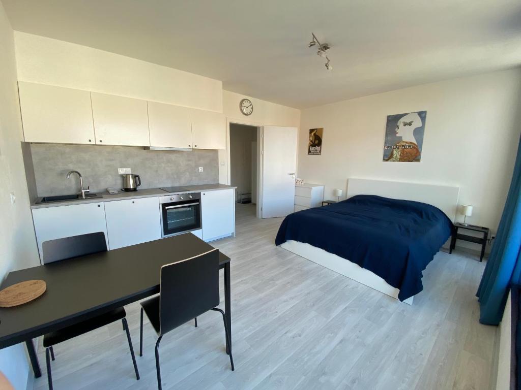ein Schlafzimmer mit einem Bett und einem Tisch sowie eine Küche in der Unterkunft COZY STUDIO WITH GARAGE IN THE CITY CENTER in Pilsen