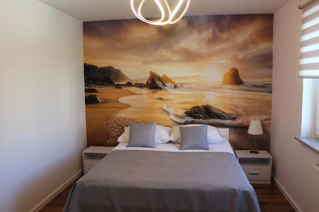 ein Schlafzimmer mit einem Gemälde des Ozeans in der Unterkunft Apartament pod Siódemką in Kołobrzeg
