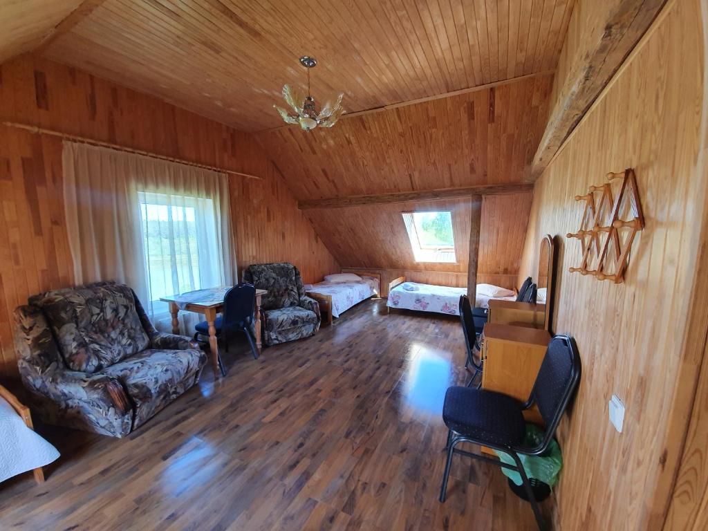 a living room with a couch and chairs in a cabin at Lauku Mājas Ēmužas in Dārte