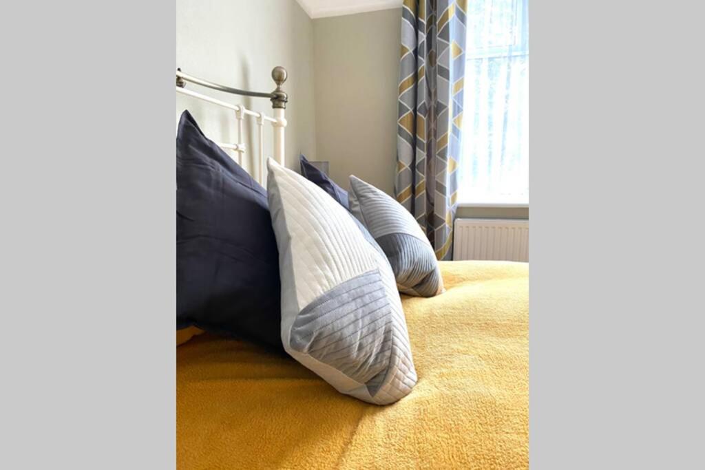 1 dormitorio con almohadas en una cama con ventana en Spacious 2 Bed APT sleeps 4 near Bournemouth Beach en Bournemouth