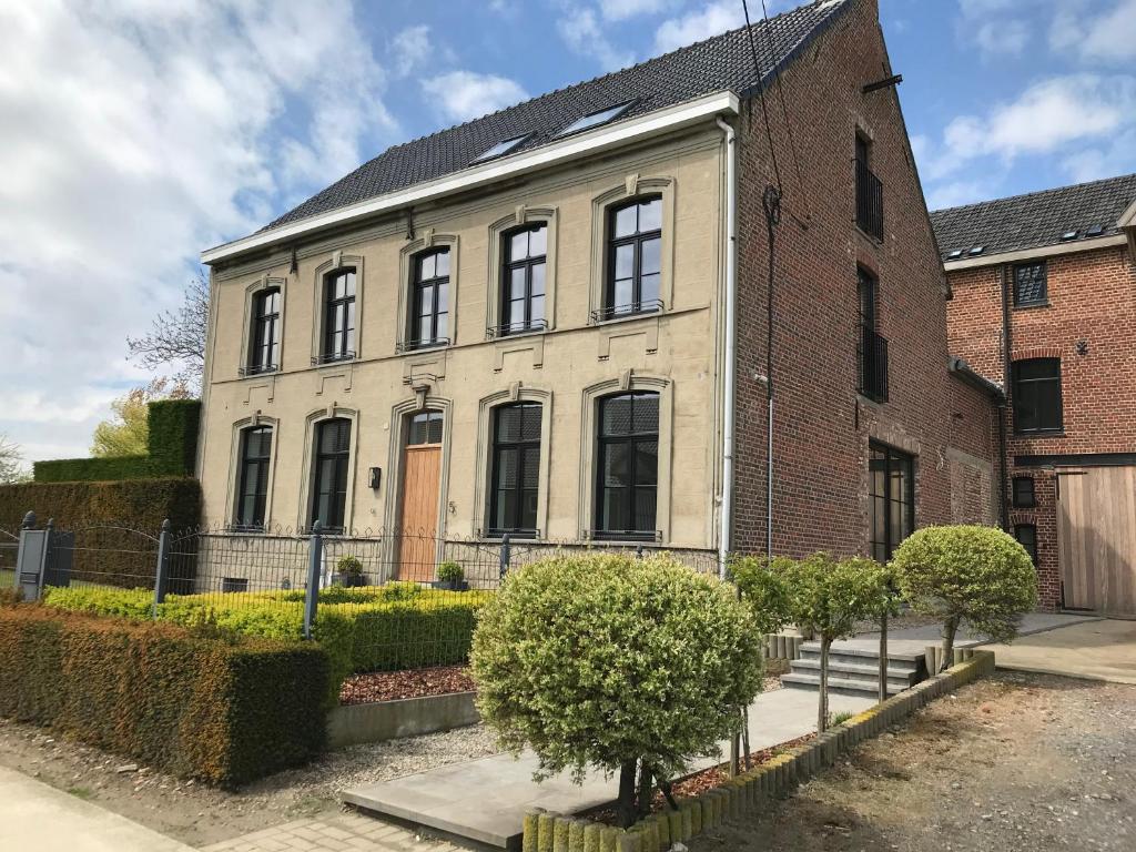 un antiguo edificio de ladrillo con ventanas negras en D'Hommelbelle, en Poperinge