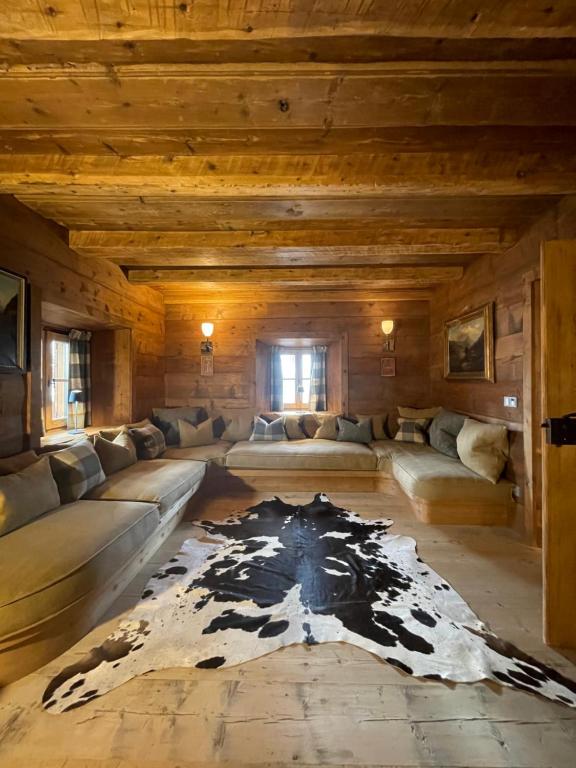 a large living room with a cow rug on the floor at Luxury Cortina in Cortina dʼAmpezzo