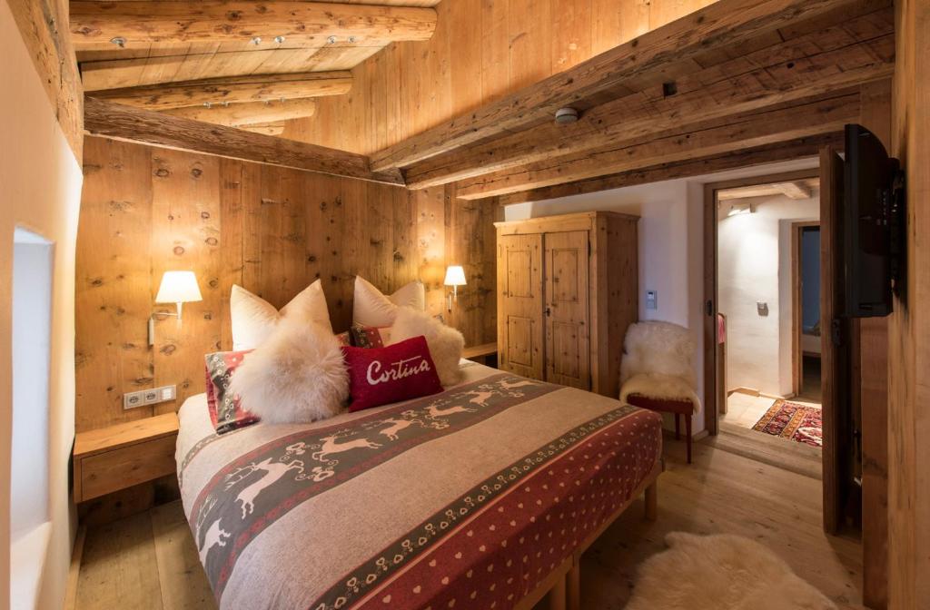 a bedroom with a large bed with wooden walls at Luxury Cortina in Cortina dʼAmpezzo