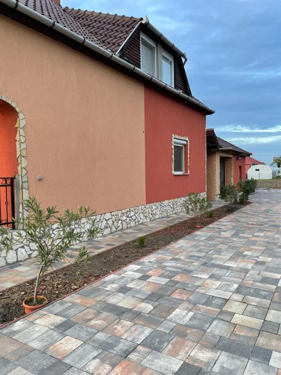 a house with a brick driveway in front of it at Adonisz Vendégház in Mórahalom