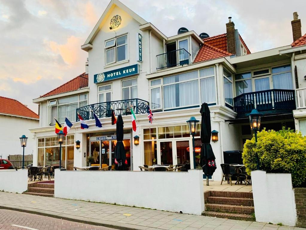 ein Hotel mit Flaggen vor einem Gebäude in der Unterkunft Hotel Keur in Zandvoort
