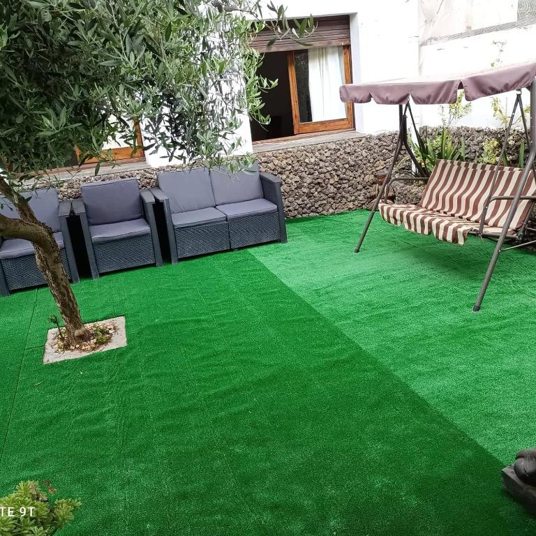 césped verde con 2 sillas y un columpio en Carrer Esparreguera, en Olot