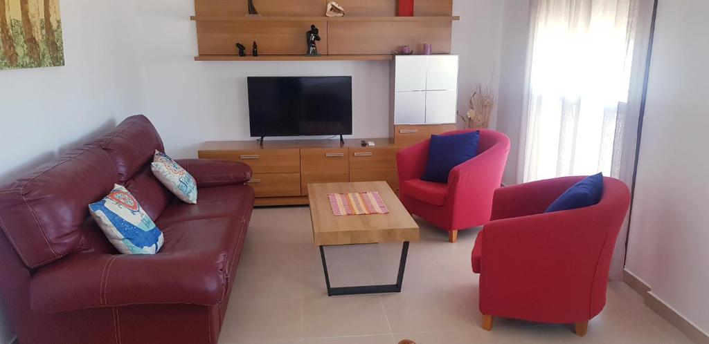 a living room with a couch and two chairs and a television at Ático Premium Conil con 2 terrazas, parking, piscina, Aire Ac y WIFI -SOLO FAMILIAS Y PAREJAS- in Conil de la Frontera
