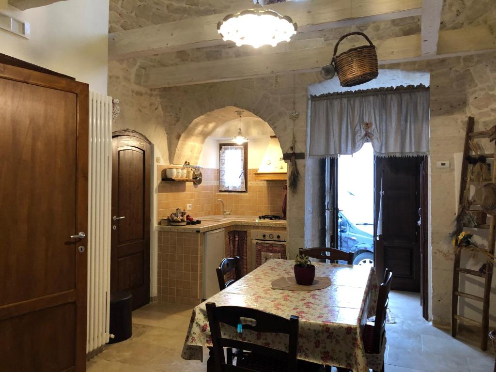 eine Küche mit einem Tisch und Stühlen sowie ein Esszimmer in der Unterkunft Trullo di Giovannina Casa Vacanza in Alberobello