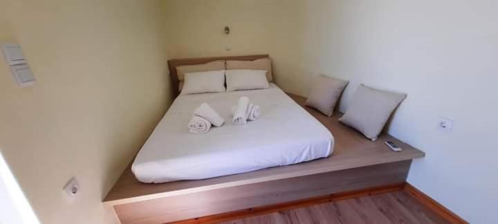 a bed with white sheets and two towels on it at Manto Apartments Lefkada in Évyiros