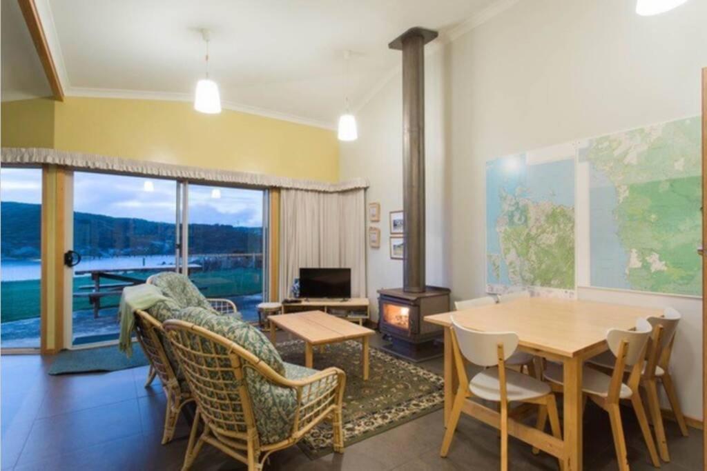 a living room with a table and chairs and a fireplace at ARTHUR RIVER LODGE - DOWN STREAM APARTMENT in Arthur River