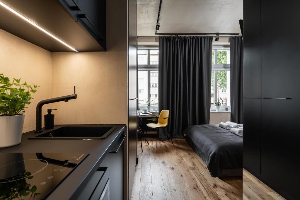 een keuken met een wastafel en een bed in een kamer bij Morning Light Sopot Apartment in Sopot