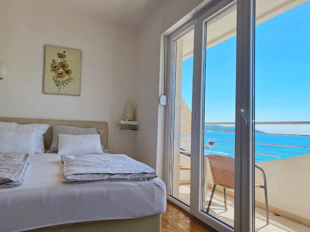 a bedroom with a bed and a view of the ocean at Apartments Bellevue - Otasevic in Herceg-Novi