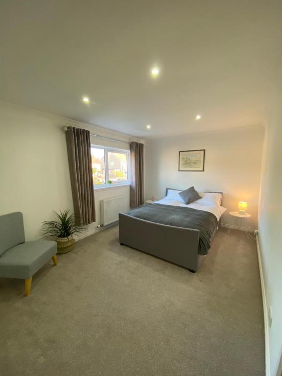 a bedroom with a bed and a chair at Sigurd House in Thurso