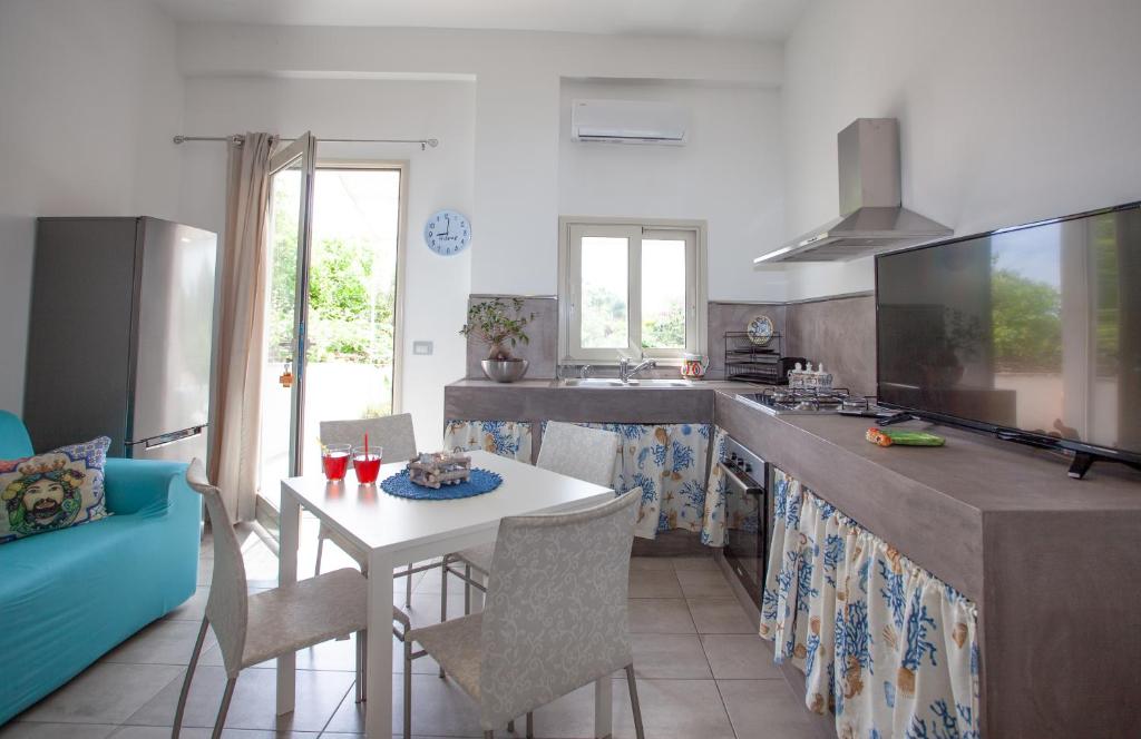 una cucina con tavolo, sedie e piano di lavoro di Casa Gioia a Giardini Naxos