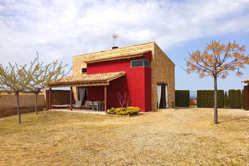 a red house with a tree in front of it at La Era De Pepe in Calaceite