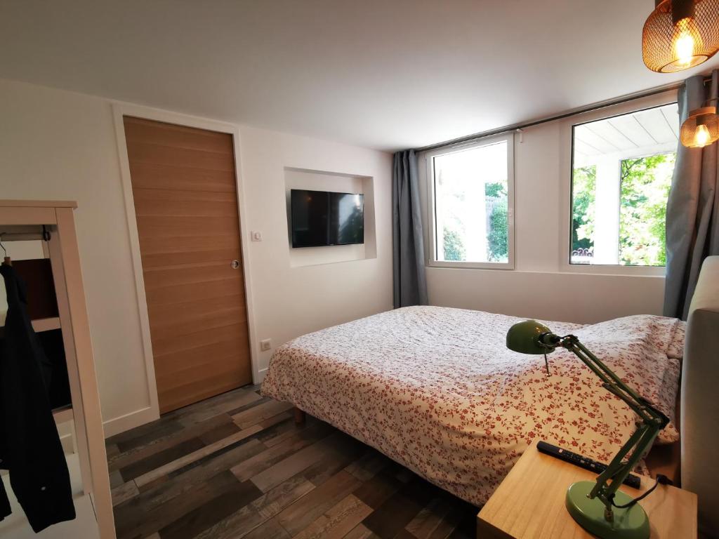 1 dormitorio con 1 cama y 1 lámpara en una mesa en Dépendance Cosy dans Maison Bordelaise à 200m du tram et du CHU en Burdeos
