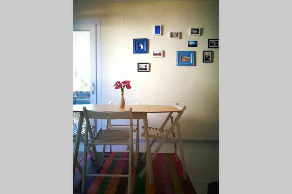 a dining room table with chairs and a vase with flowers at Acogedor apartamento en la zona de las Fuentes con WiFi in Alcossebre