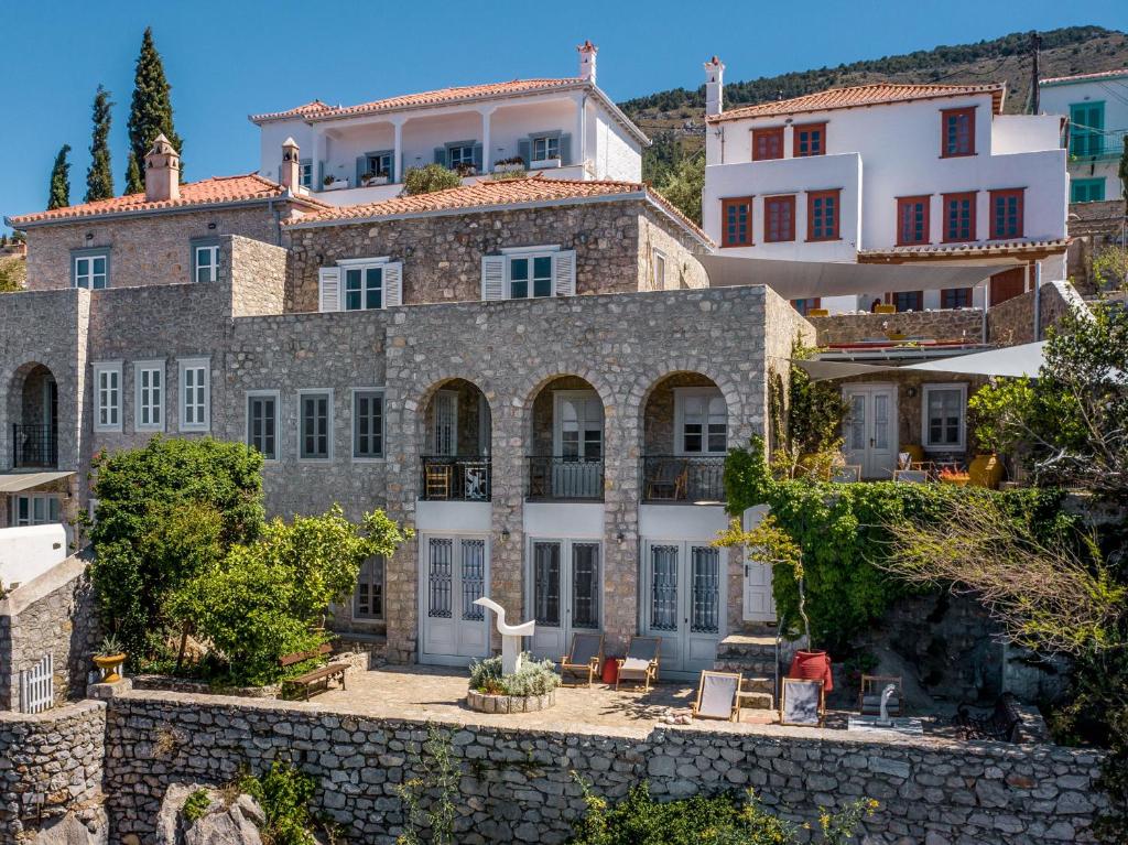 a large stone house with a stone wall at ONOS RESIDENCE in Hydra