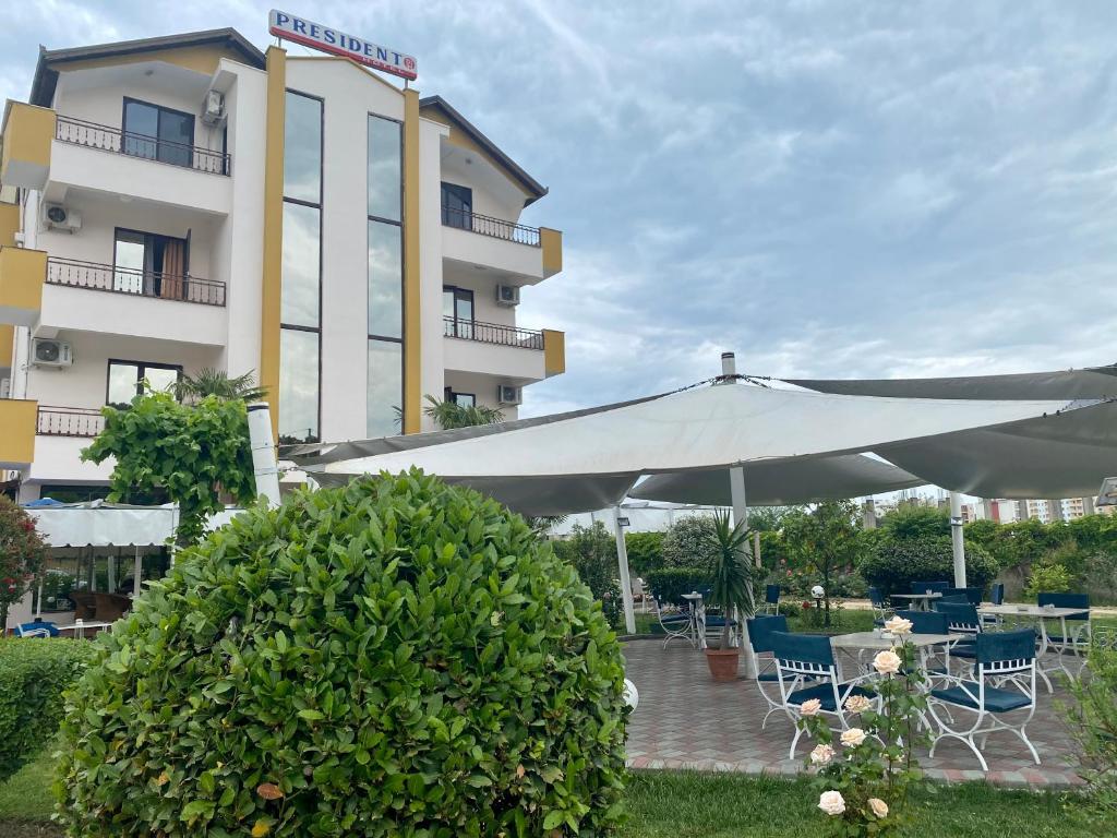 a large white umbrella in front of a building at Hotel President in Golem