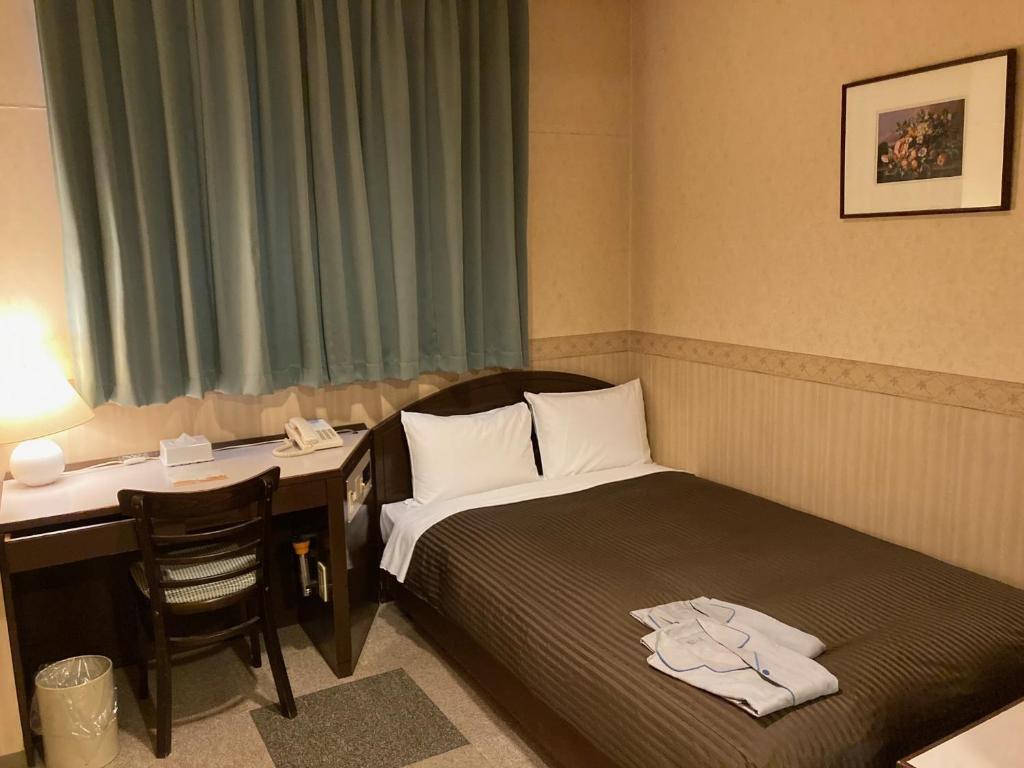 um quarto de hotel com uma cama e uma secretária e uma mesa e uma secretária em Hotel Hamilton Sapporo - Vacation STAY 27954v em Sapporo