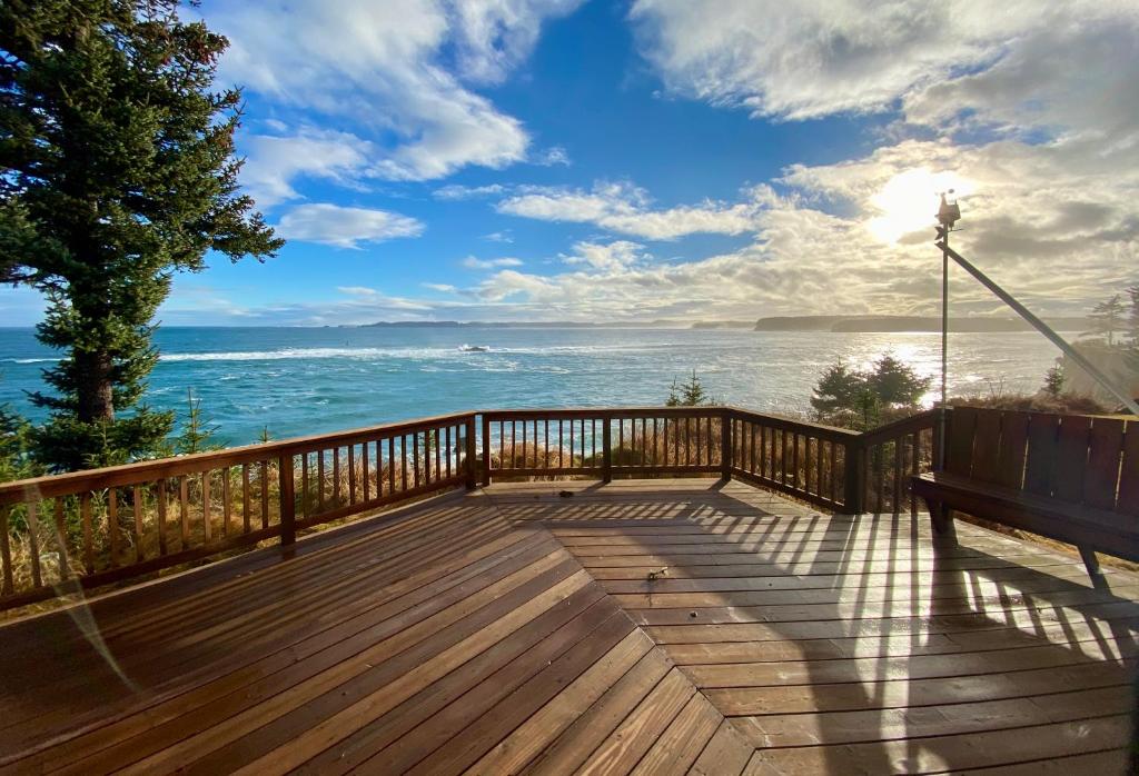 a wooden deck with a bench overlooking the ocean at Goldilocks Bed & Breakfast in Kodiak