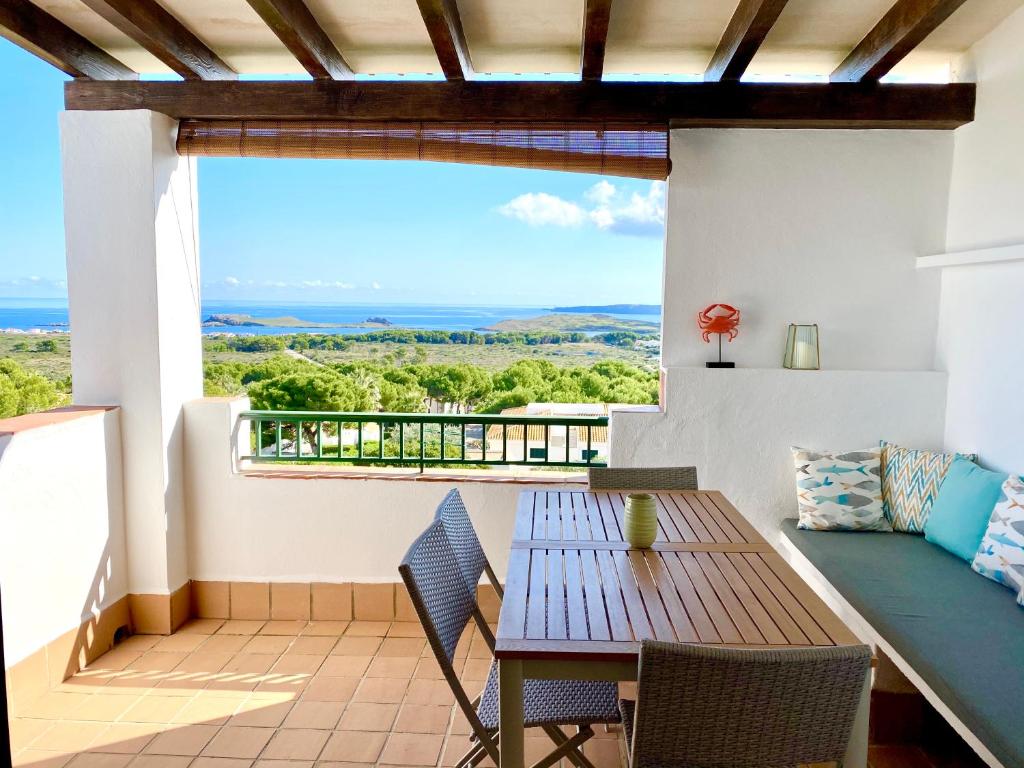 balcone con tavolo, sedie e vista di La Terraza de la Sabina a Es Mercadal