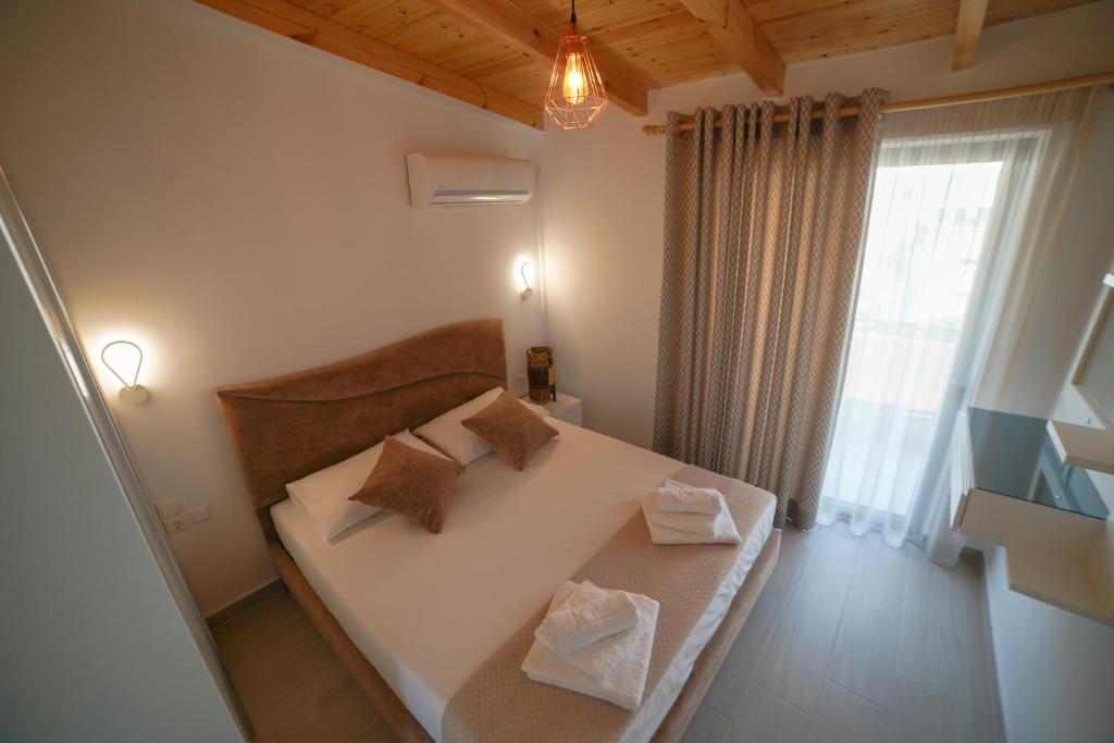 a bedroom with a bed with two pillows and a window at City Glow Apartments in Sarandë