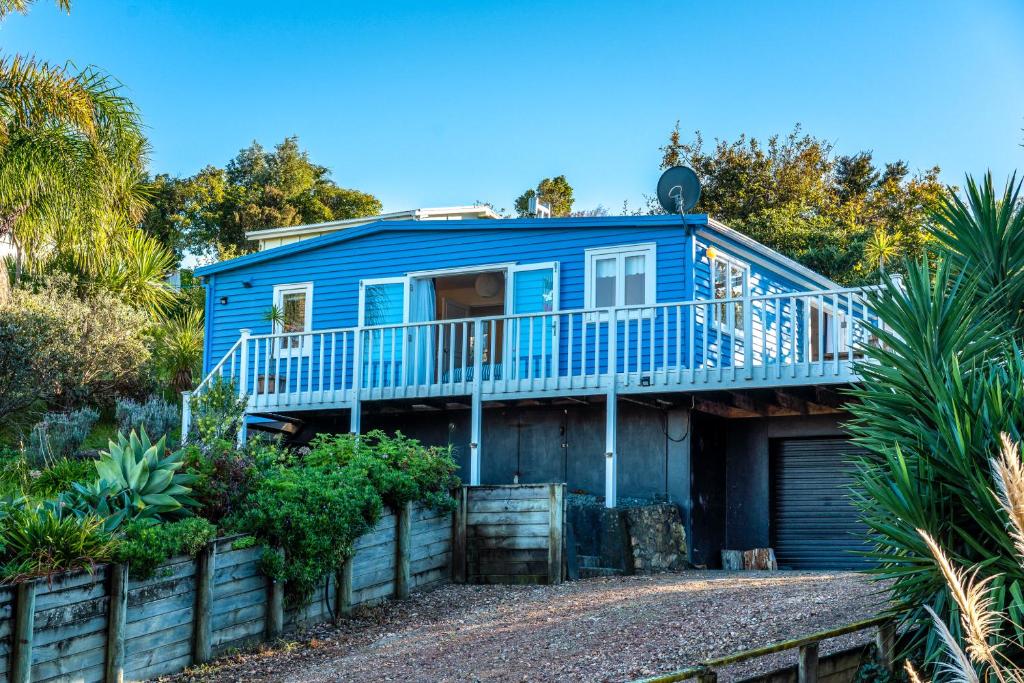 Cette maison bleue dispose d'une terrasse couverte et d'un balcon. dans l'établissement The Butterfly Bach - Surfdale Holiday Home, à Surfdale