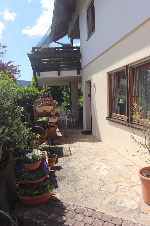 eine Terrasse mit Topfpflanzen neben einem Haus in der Unterkunft Ferienwohnung Pimer in Ranschbach